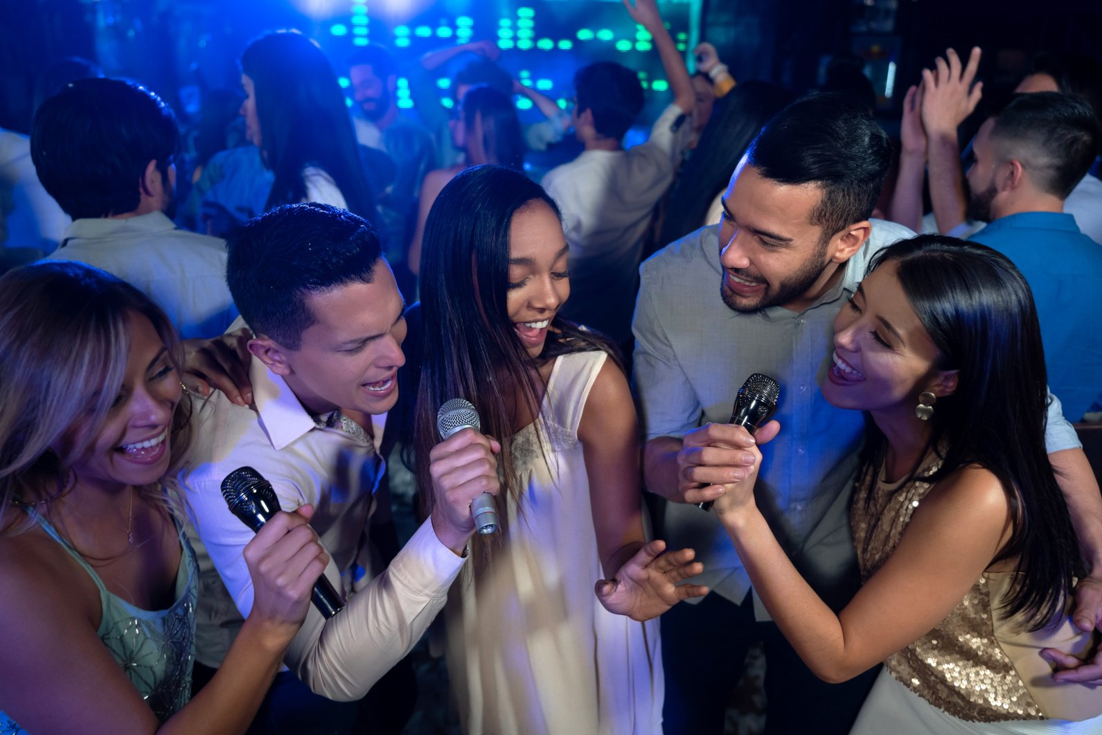 Group of friends singing karaoke at a bar